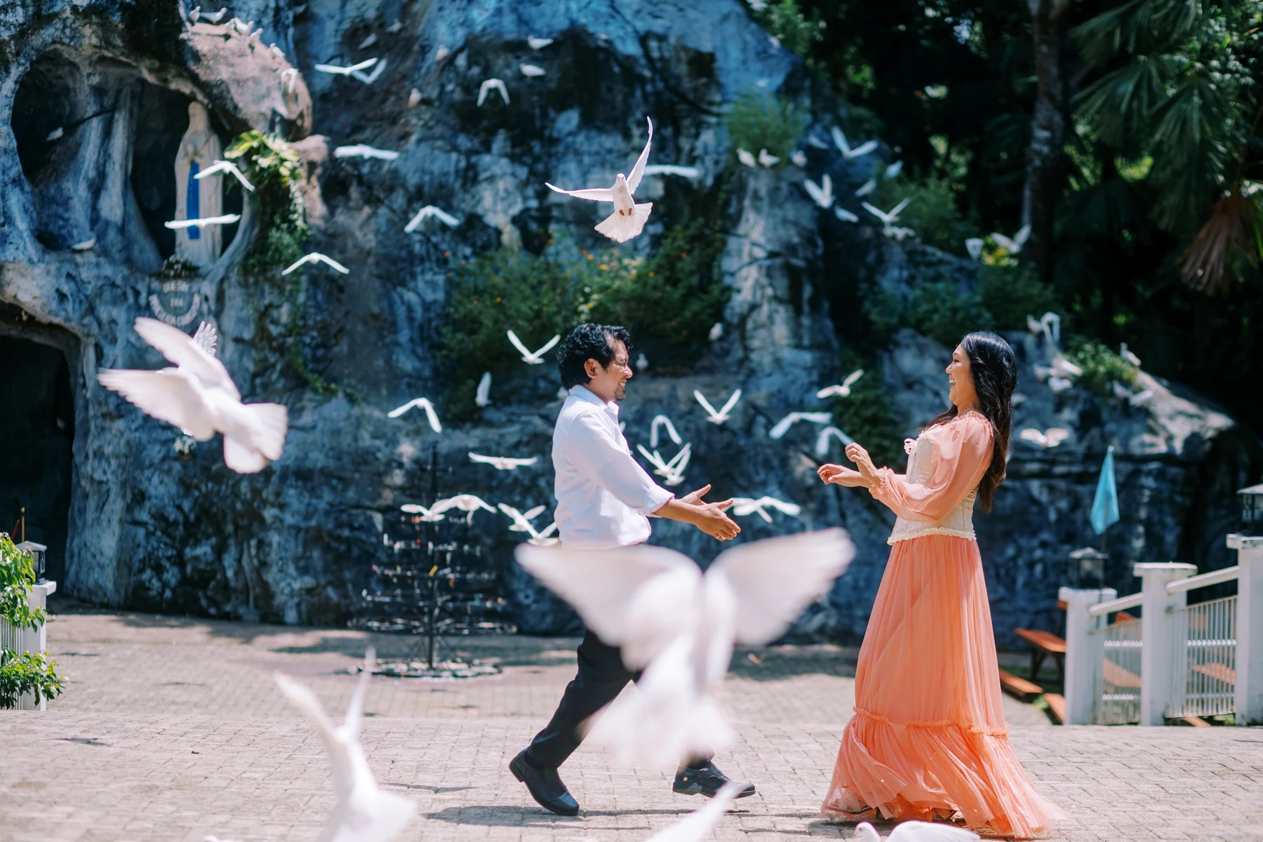 Dancing together as white birds fly across the courtyard
