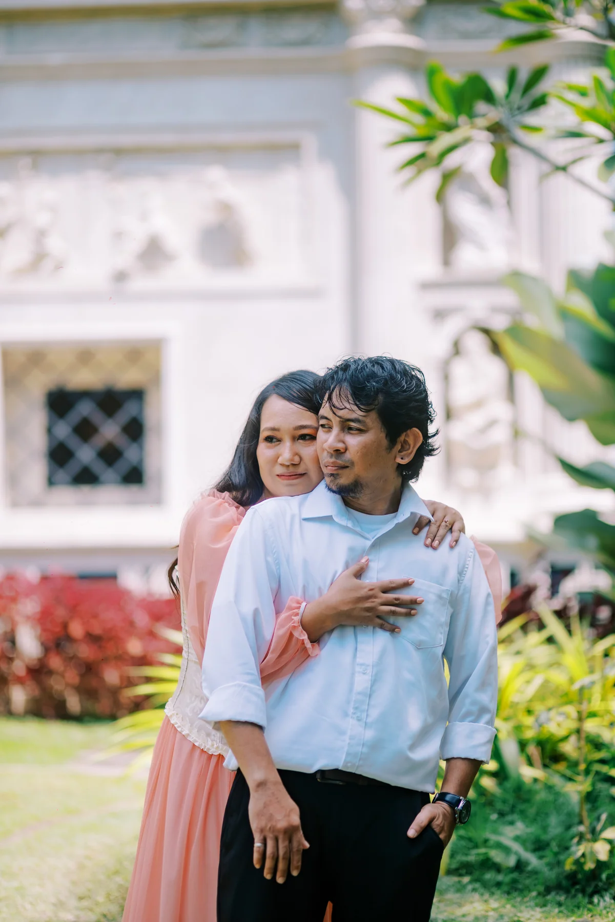 An embrace in front of an ornate white building