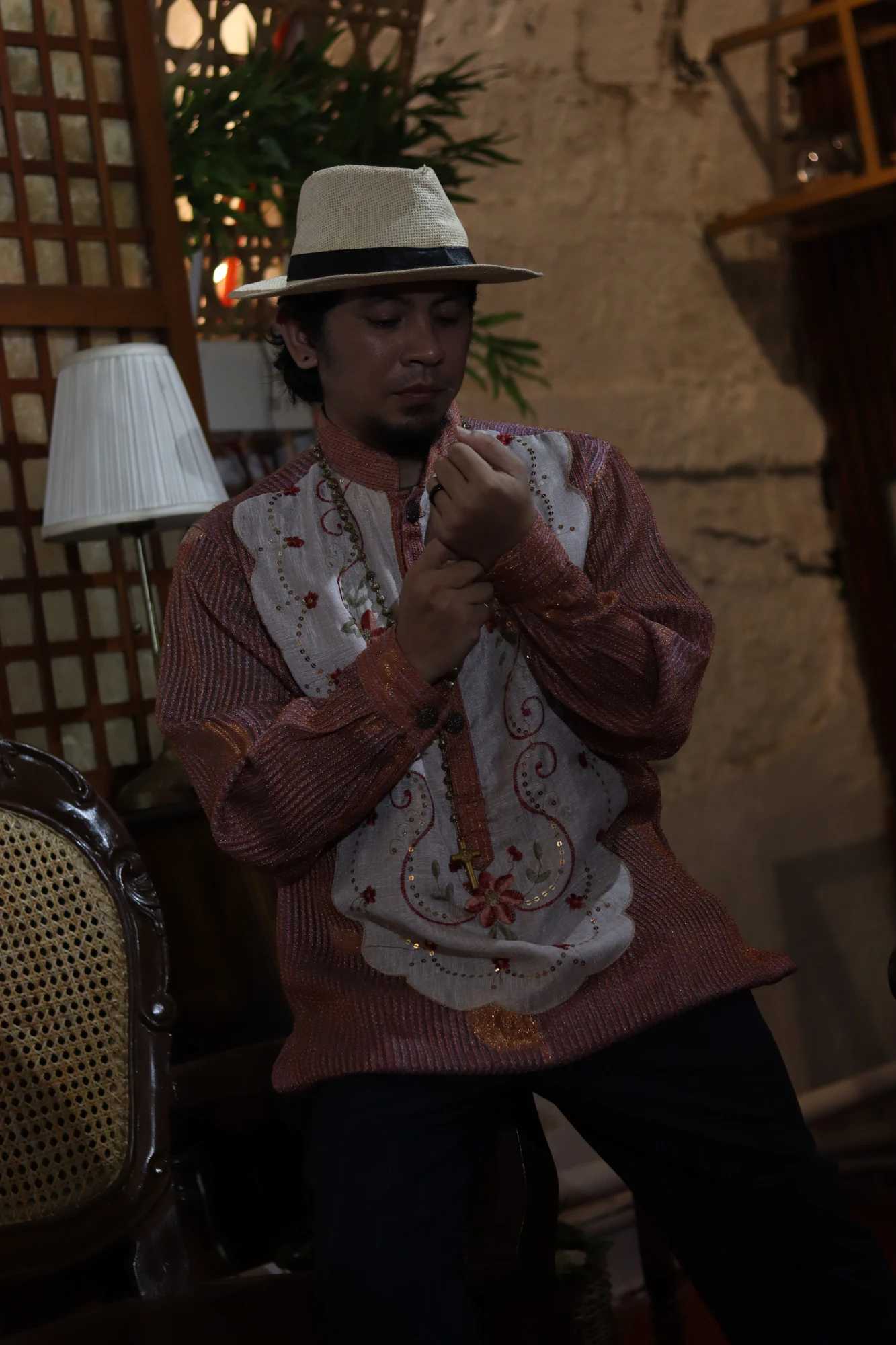 Clive adjusting his embroidered Barong cuff in a heritage room